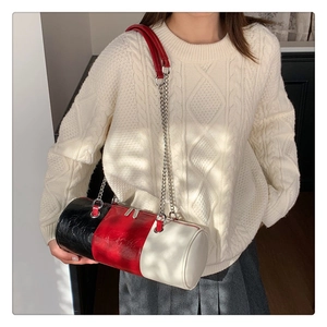 Détail du sac cylindre tricolore avec bandoulière chaîne argentée et cuir brillant fini