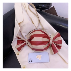 Détail du sac bandoulière en forme de bonbon avec rayures rouges et blanches et nœuds