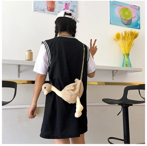 Détail d'un mignon sac bandoulière en peluche cygne blanc porté par un mannequin