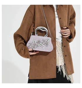 Detail of purple glitter evening bag with crystal leaf ornaments and silver metal handle