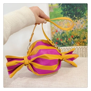 Détail du sac à bandoulière en forme de bonbon avec rayures jaunes et magenta et sangle