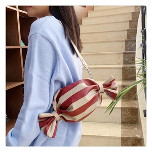 Détail d'un sac bandoulière en forme de bonbon avec rayures rouges et blanches