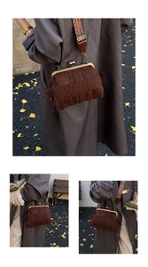 Detail van bruine retro schoudertas met franjes, metalen sluiting en bedrukte riem