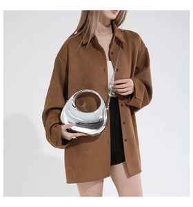 Silver metallic moon-shaped mini bag with chain strap styled on suede brown shirt