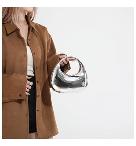 Close-up of a silver mirror acrylic crescent bag with a high-gloss reflective metallic finish