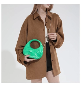 Detail of green marble acrylic crescent bag with gold chain and round hollow handle