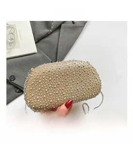 Detail showing interior capacity of champagne gold evening bag with silver rivets