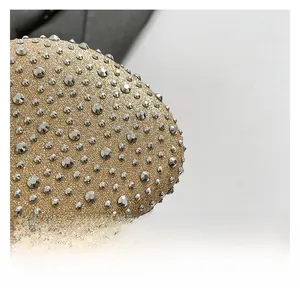 Macro shot of gold glitter fabric surface with silver metallic studs on luxury handbag