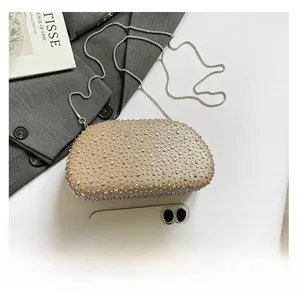 Top view of champagne rhinestone evening bag with chain strap and iPhone for scale