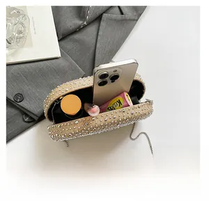 Detail of oval rhinestone evening bag with chain showing storage for phone and lipstick