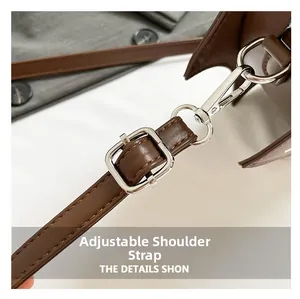 Detail of adjustable dark brown leather strap with silver metal buckle and swivel hook