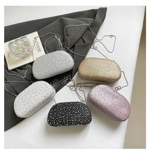Detail shot of shimmering rhinestone evening clutch bags in multiple colors with chain straps