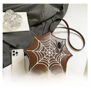 Macro detail of brown spider web embroidered crossbody bag with black spider patch