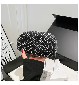 Detail of a black evening clutch with silver rhinestones on a luxury gift box