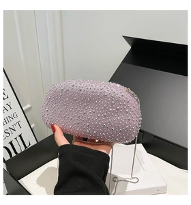 Close-up of pink sequined clutch bag with silver rhinestones and metal chain strap