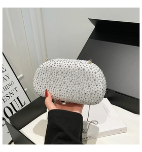 Detail of elegant shell-shaped evening clutch bag featuring rows of sparkling rhinestones