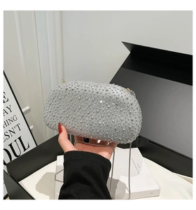 Detailed view of silver evening bag with sparkling rhinestones and chain strap