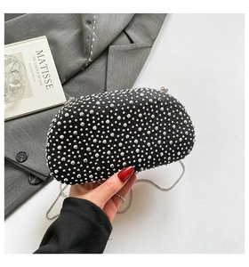 Close-up of black evening clutch bag with sparkling rhinestones and silver chain strap