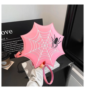 Detail of pink spider web handbag with 3D black spider and glossy leather texture