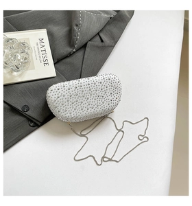 Detailed macro view of sparkling silver rhinestone clutch bag with delicate metal chain strap