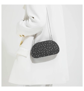 Close-up of elegant black evening clutch bag featuring silver rhinestones and chain strap