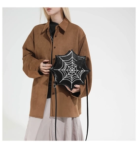 Detail of Halloween spider web crossbody bag worn by a model in a studio setting