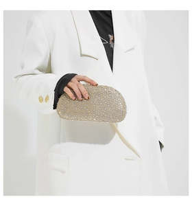 Close-up of sparkling silver rhinestone handbag with elegant champagne base and chain strap