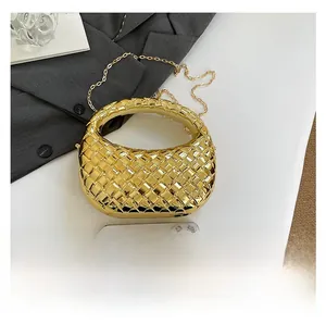 Dettaglio ravvicinato di una borsa a mano dorata in metallo intrecciato con catena
