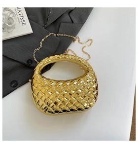 Close-up of golden woven half-moon acrylic evening bag with a metal chain strap