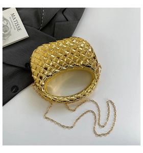 Macro detail of golden woven texture and chain strap on minimalist dumpling bag