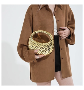 Detail of gold woven metallic round handbag featuring luxury intrecciato pattern
