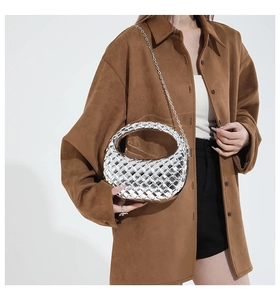 Borsa hobo intrecciata argento con tracolla a catena in metallo indossata dal modello