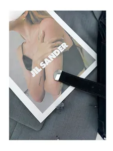 Detail of black suede belt with square silver metal tip on fashion magazine background