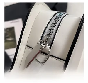 Detailed macro view of high-quality silver metal zipper on a white leather ghost handbag