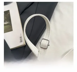 Detail of adjustable white leather shoulder strap with polished silver metal buckle