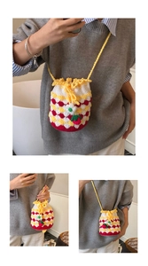 Detail of handmade crochet strawberry bucket bag with vibrant red and yellow knit texture