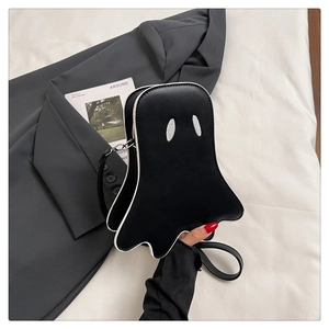 Close-up of black ghost crossbody bag with white piping and long leather shoulder strap
