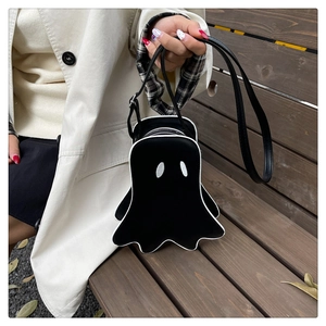 Detail of a ghost-shaped Halloween crossbody bag with white eyes and adjustable strap