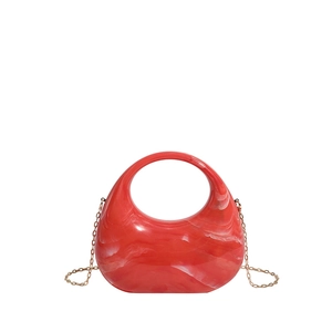 Detailed view of red marble acrylic half-moon handbag with elegant gold chain strap