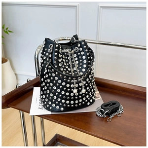 Detail of studded black bucket bag with pearl drawstring and silver chain strap