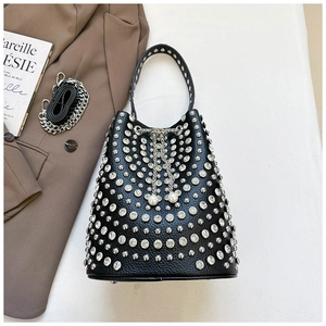Detailed view of black pebbled leather bucket bag with silver studs and pearl accents