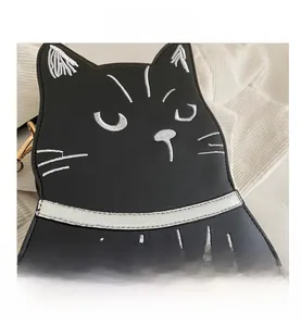 Close-up of black cat shoulder bag featuring silver embroidery and gold metal hardware