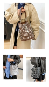 Detail of studded bucket bag with silver rivets, drawstring closure and chain strap