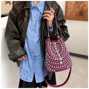 Detail of purple bucket bag featuring silver rivets and pearl chain drawstring