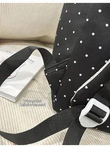 Close-up of triangle reinforced stitching on polka dot backpack shoulder straps