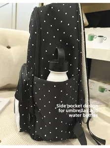Detailed side view of the polka dot backpack showing the functional water bottle pocket