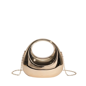 Close-up of sleek gold half-moon clutch with round handle and metallic chain strap