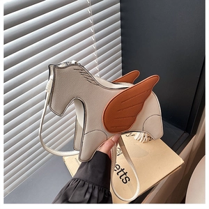 Detail of horse-shaped crossbody bag featuring creamy white faux leather and brown wings