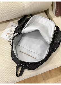 Internal view of the polka dot backpack showing the large capacity and zipper pocket