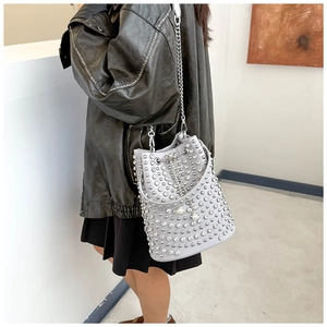 Close-up of light gray bucket bag featuring silver rhinestones and metal chain strap